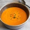 bowl of tomato soup with a spoon next to the bowl