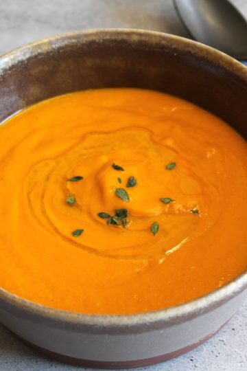 bowl of tomato soup with a spoon next to the bowl