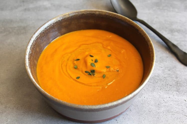 bowl of tomato soup with a spoon next to the bowl