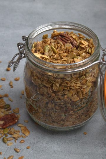 jar filled with granola and a little bit spilled on the ground next to the jar