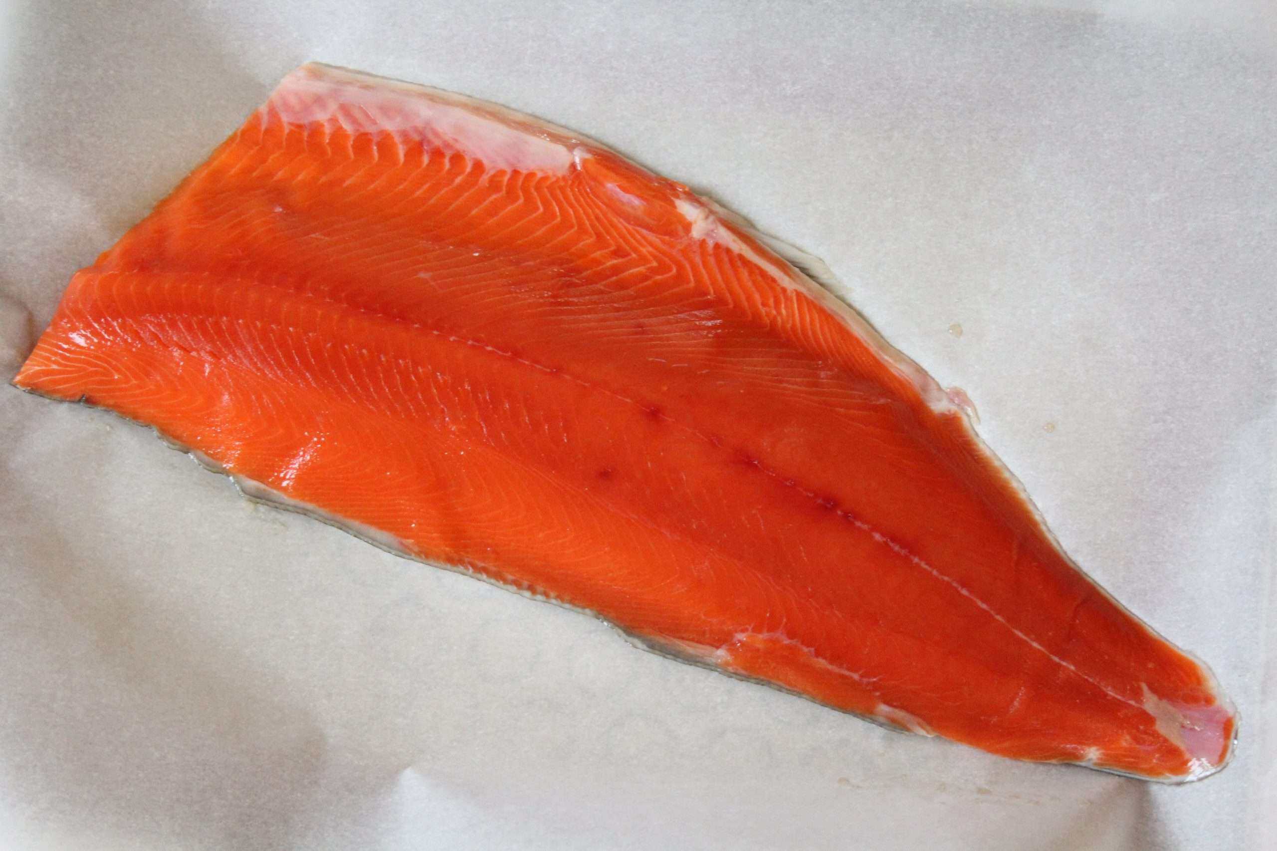 a side of salmon on a sheet of parchment paper