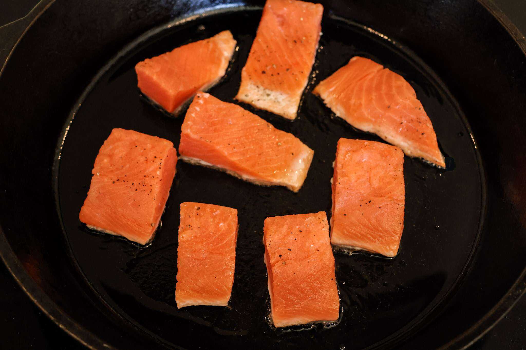 8 large chunks of salmon sauteing skin side down, in a cast iron pan