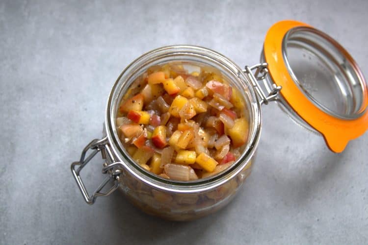an open jar filled with apple chutney