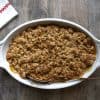 Baking dish with pear crisp and a white and red napkin on the side