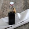 bottle of cinnamon orange balsamic reduction with a bow and a slice of dried orange around it