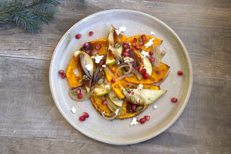 plate with roasted squash, shallots, pears, goat cheese, pomegranate seeds and a drizzle of balsamic reduction