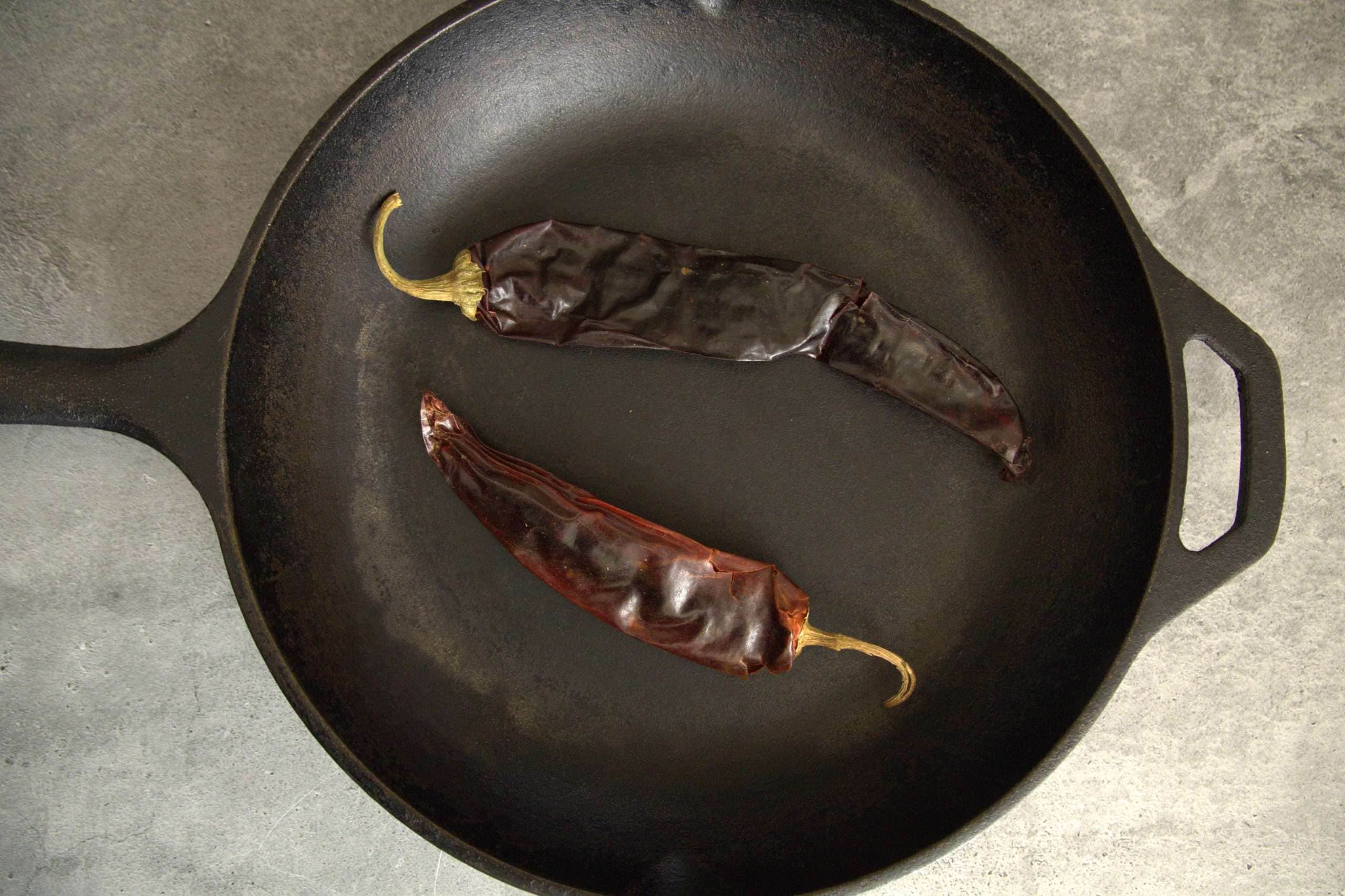 2 guajillo chilies in a cast iron skillet