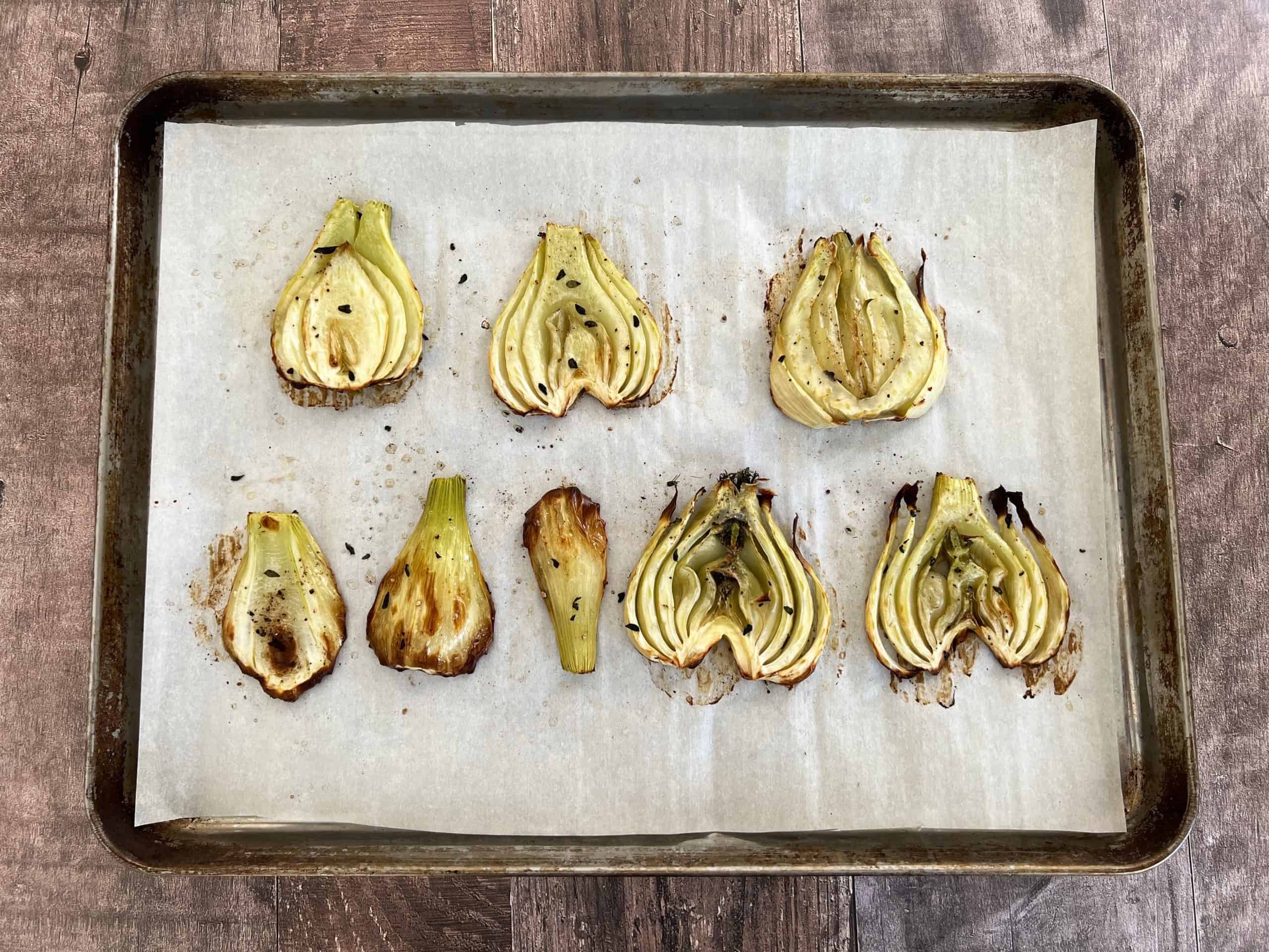 roasted fennel slices on a parchment lined baking sheet