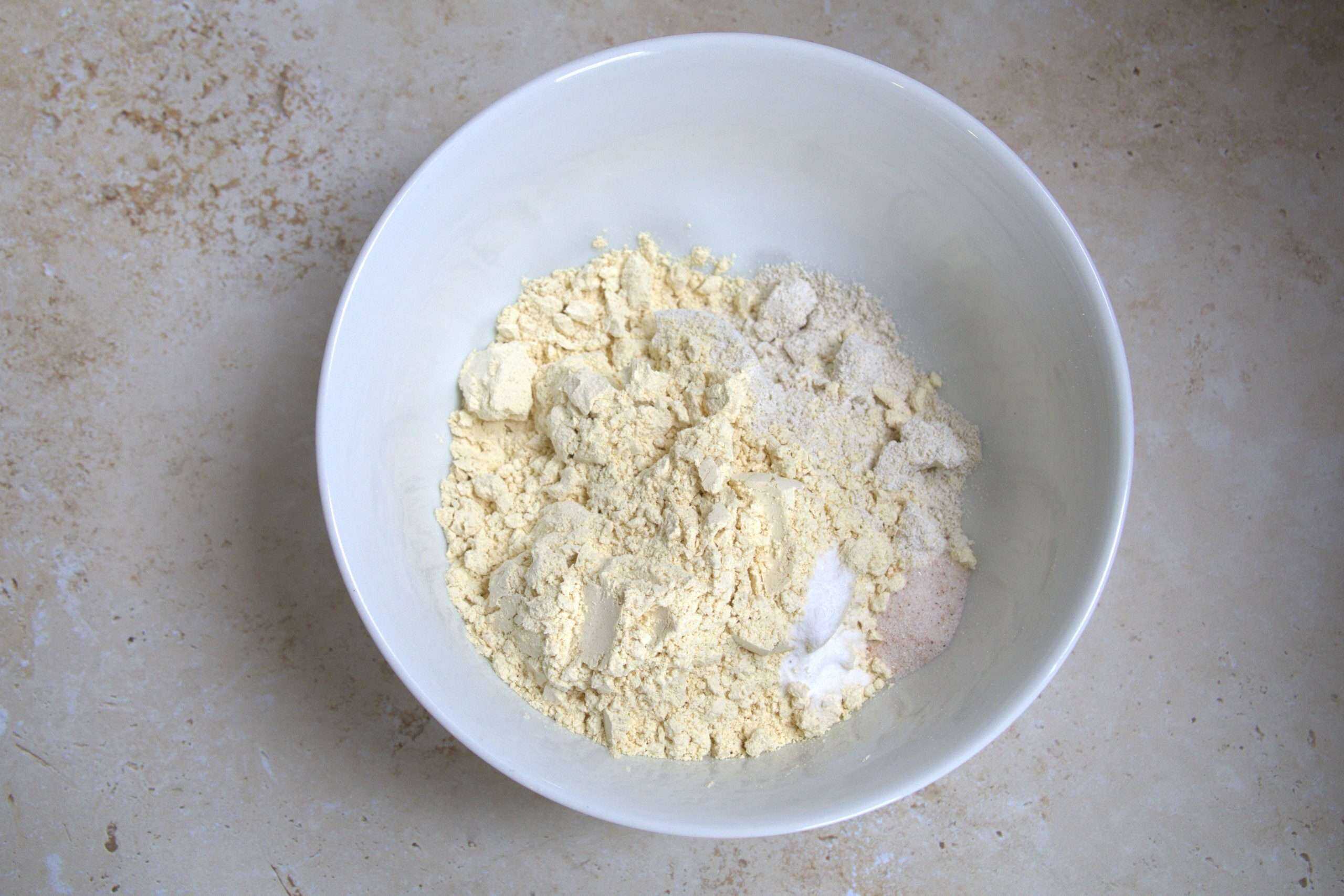 Dry ingredients, including oat- and chickpea flours, fine sea salt and baking soda in a bowl