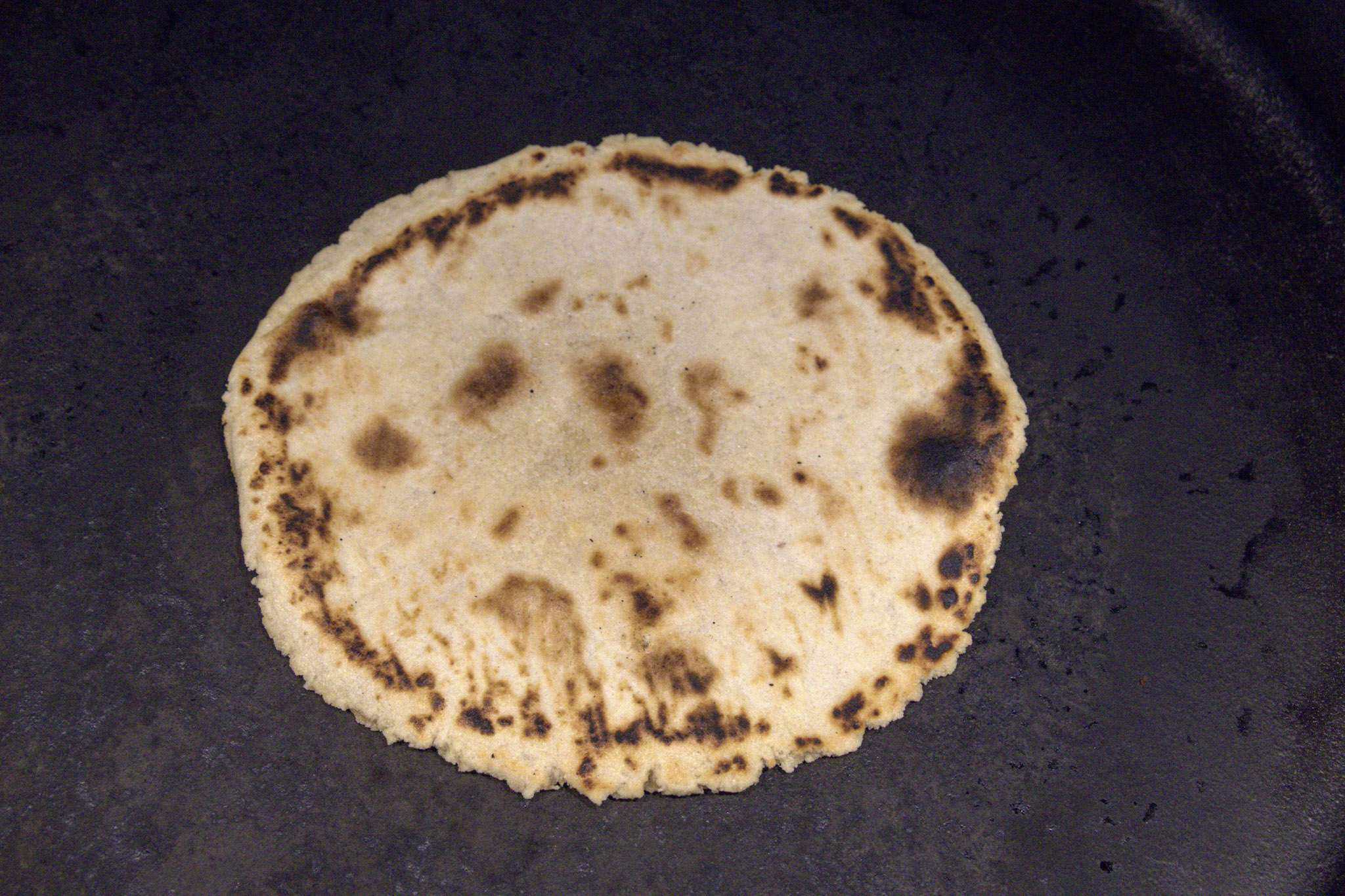 a chickpea and cassava tortilla in a pan with the cooked side up