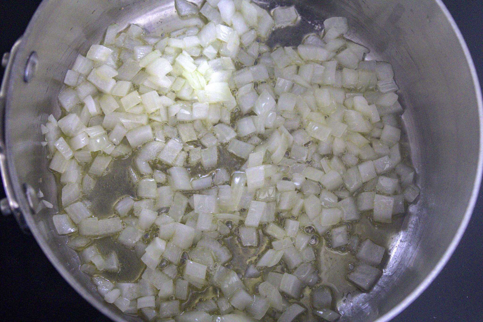 A pot with diced onions sauteing in it