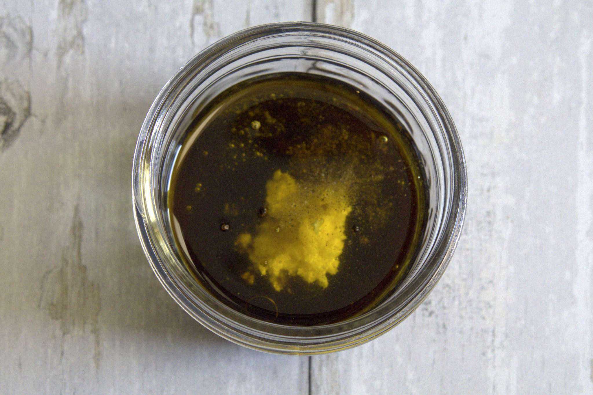 A jar with all the ingredients for ginger balsamic dressing prior to blending
