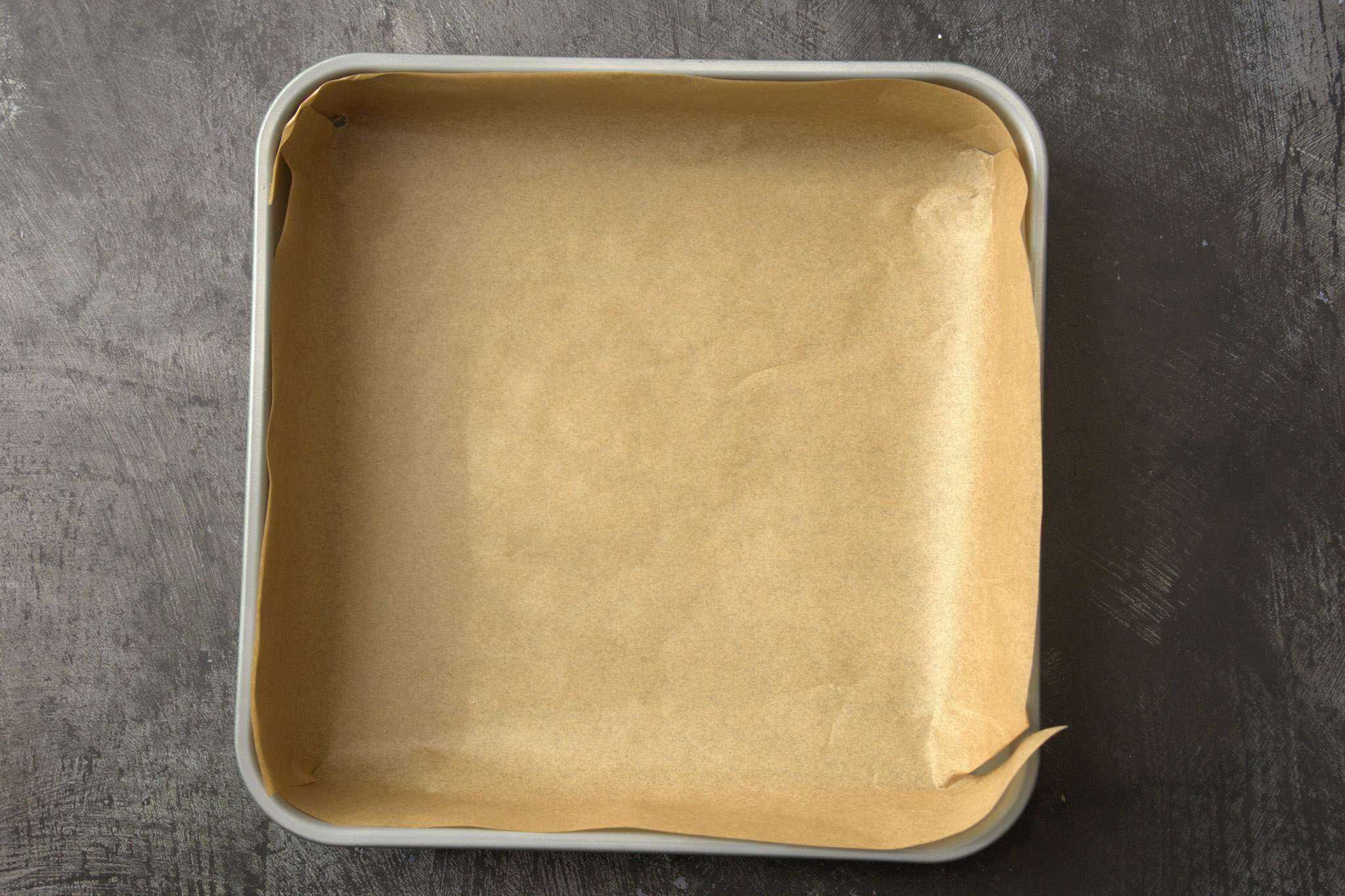A parchment lined 9x9 baking pan