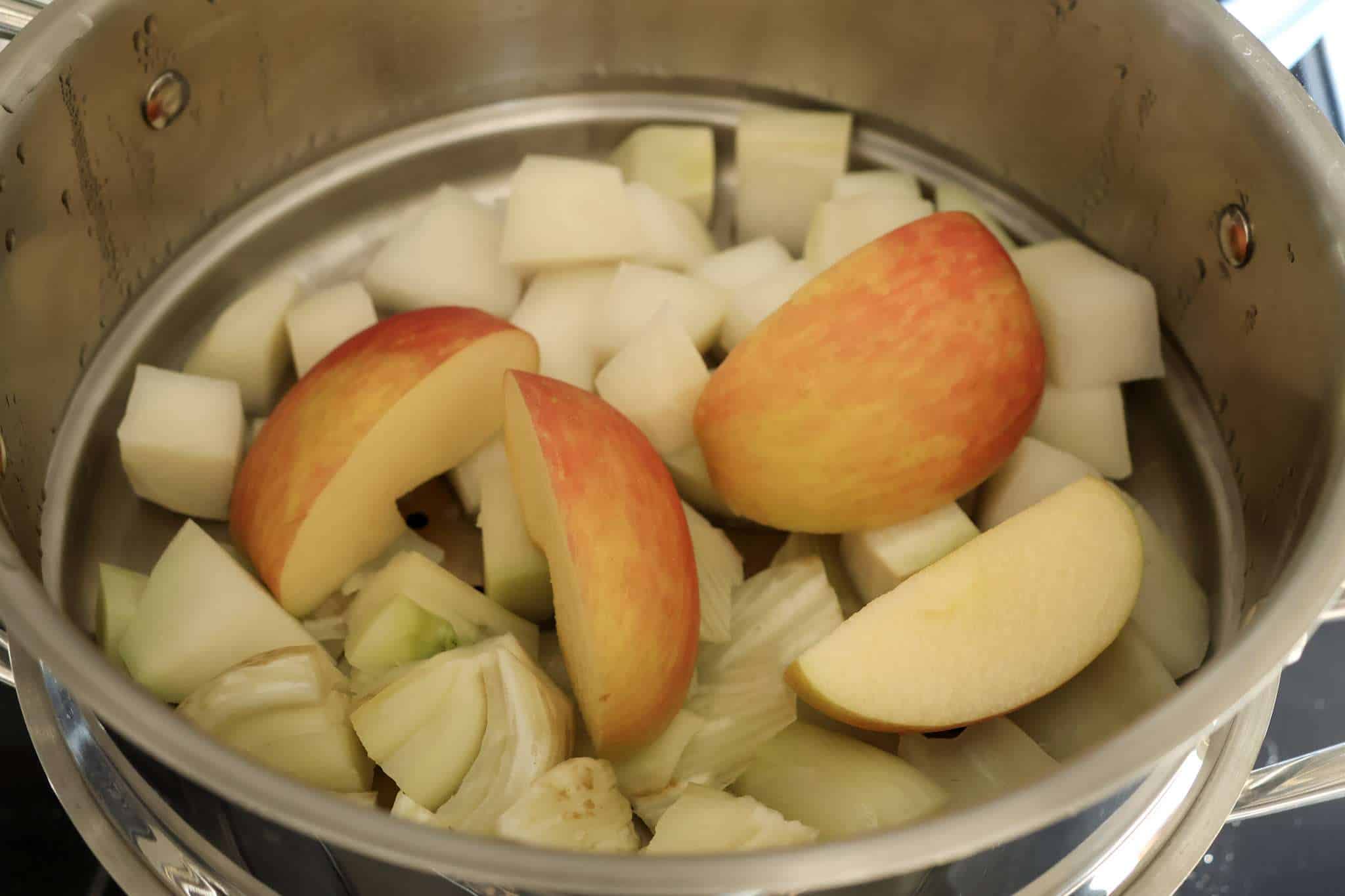 A steamer basket with chopped fennel, kohlrabi, and apples