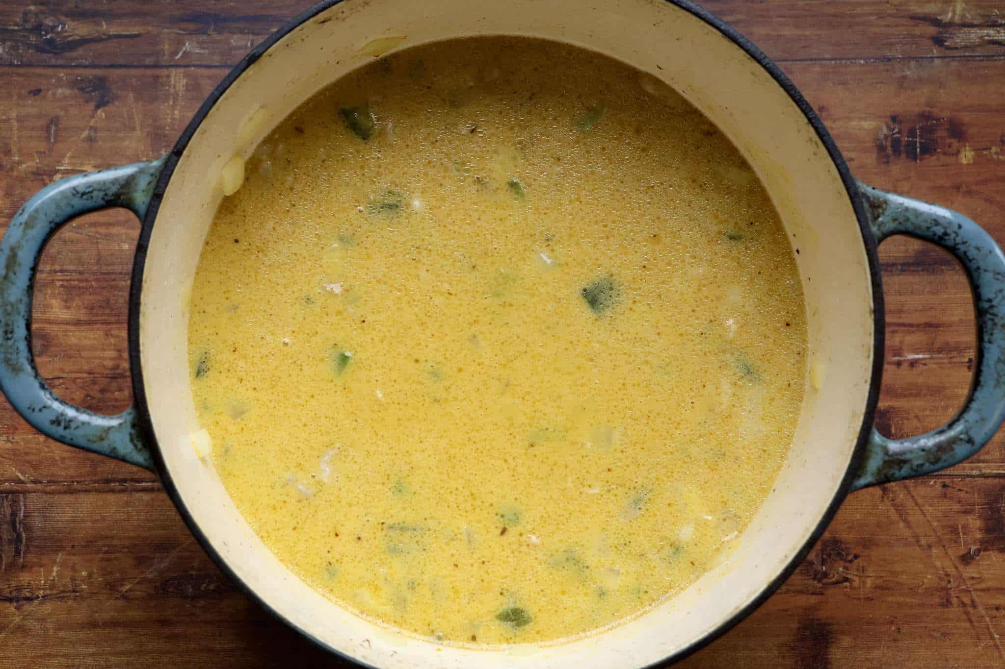 a dutch oven with creamy pumpkin and chicken chili cooking