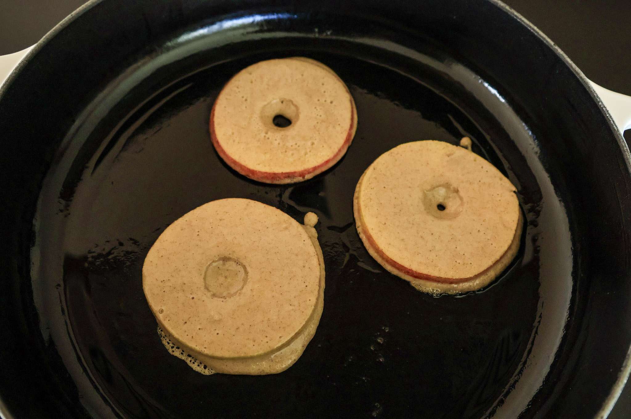 3 apfelringe cooking in a skillet