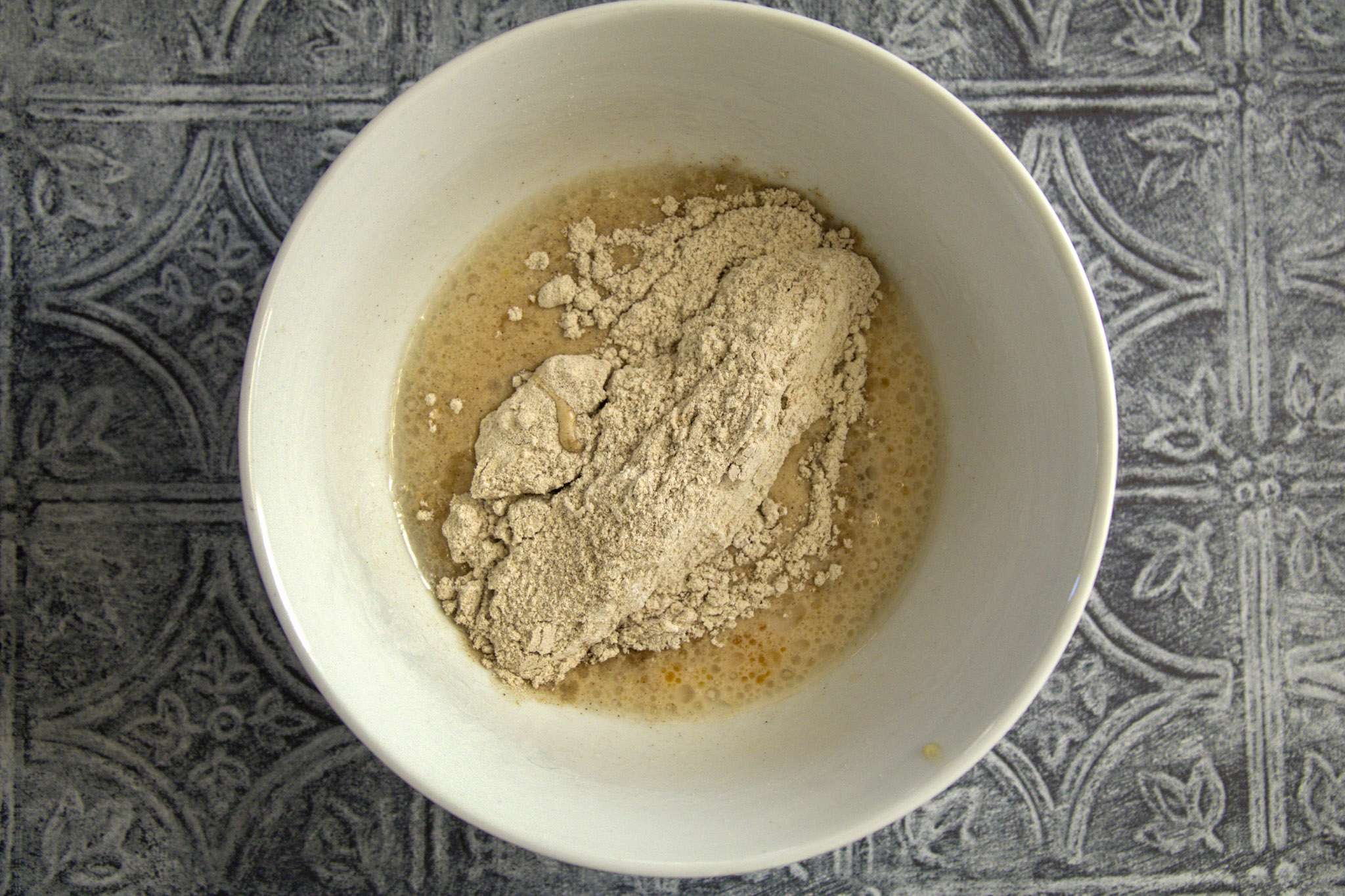 wet ingredients and dry ingredients for apfelringe in a white bowl, waiting to be blended together