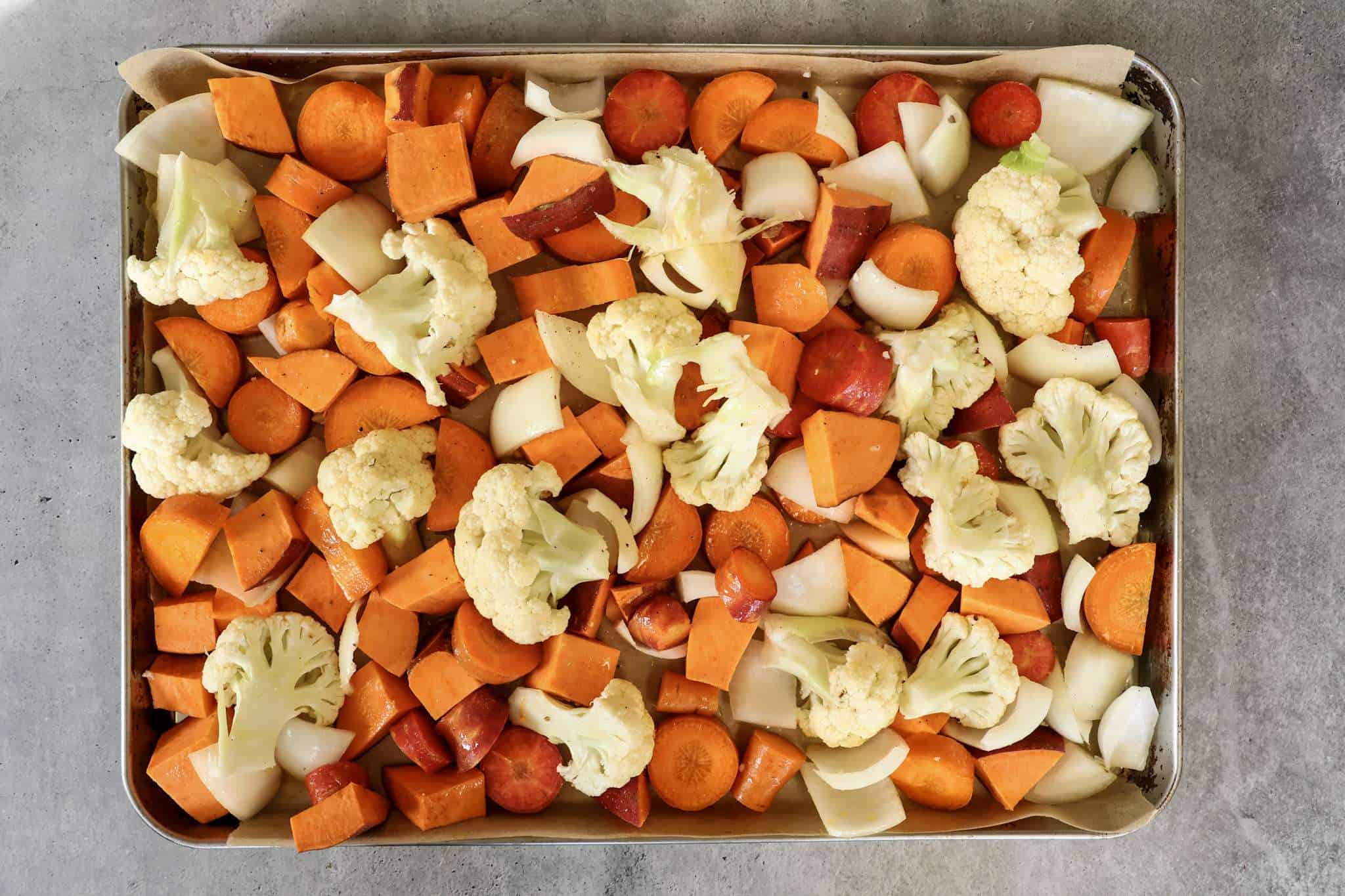 a baking sheet with vegetables for creamy winter vegetable soup ready to be roasted