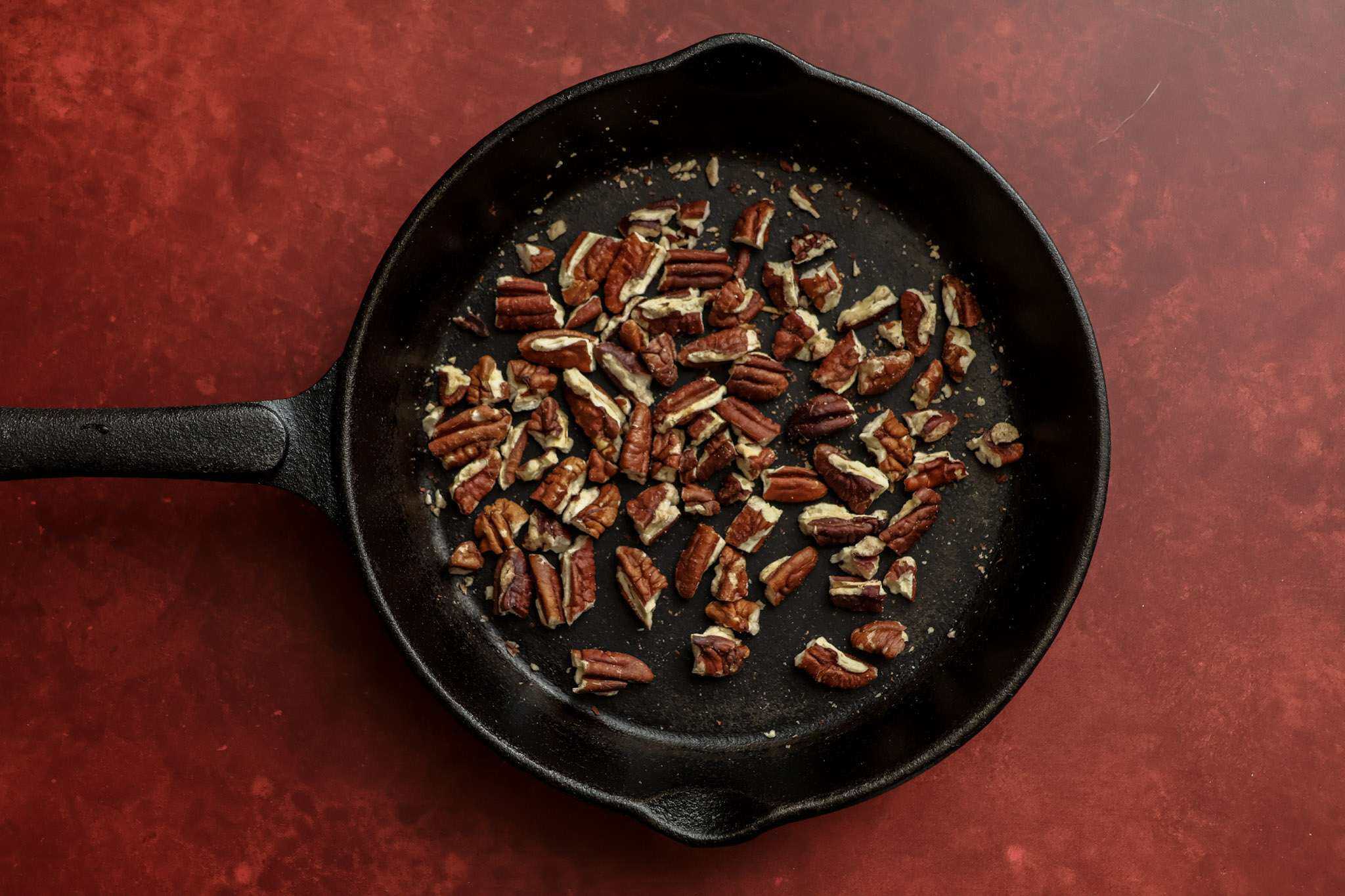 a small cast iron skillet with chopped pecans