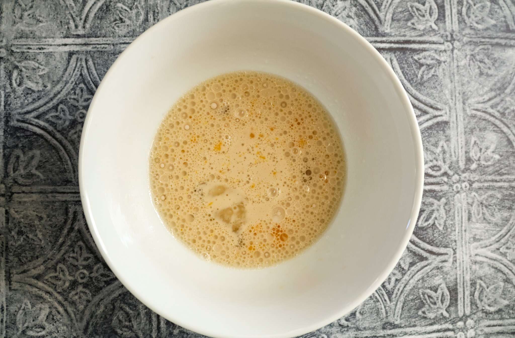 Blended wet ingredients for apfelringe in a white bowl