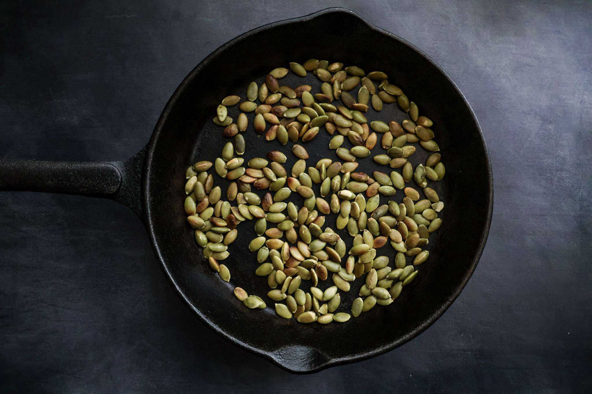 A cast iron skillet with toasted pumpkin seeds