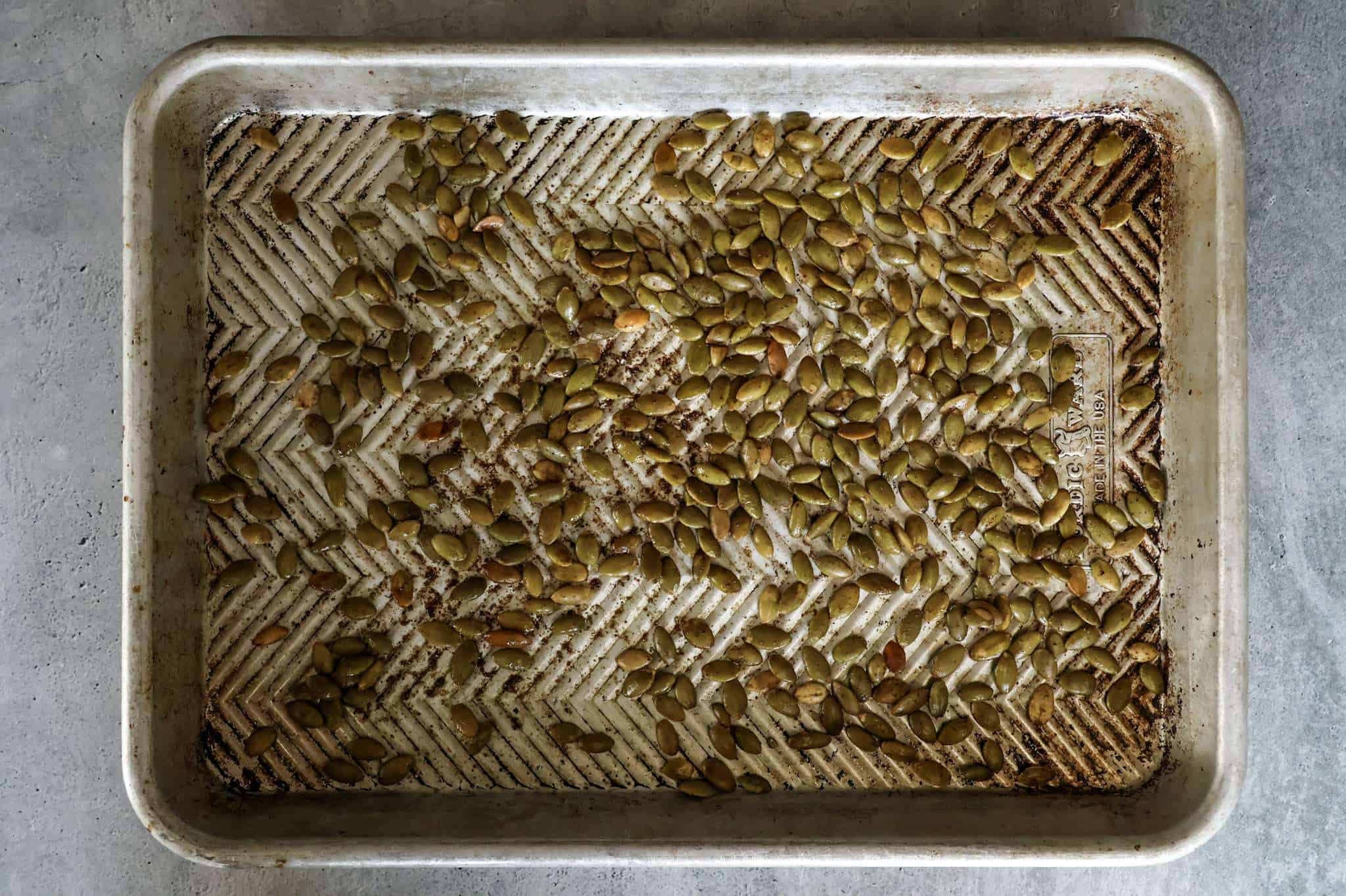 a baking sheet with toasted pumpkin seeds