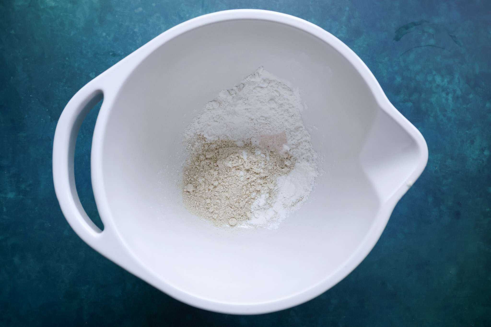 a white bowl containing the dry ingredients for cranberry tiramisu pie