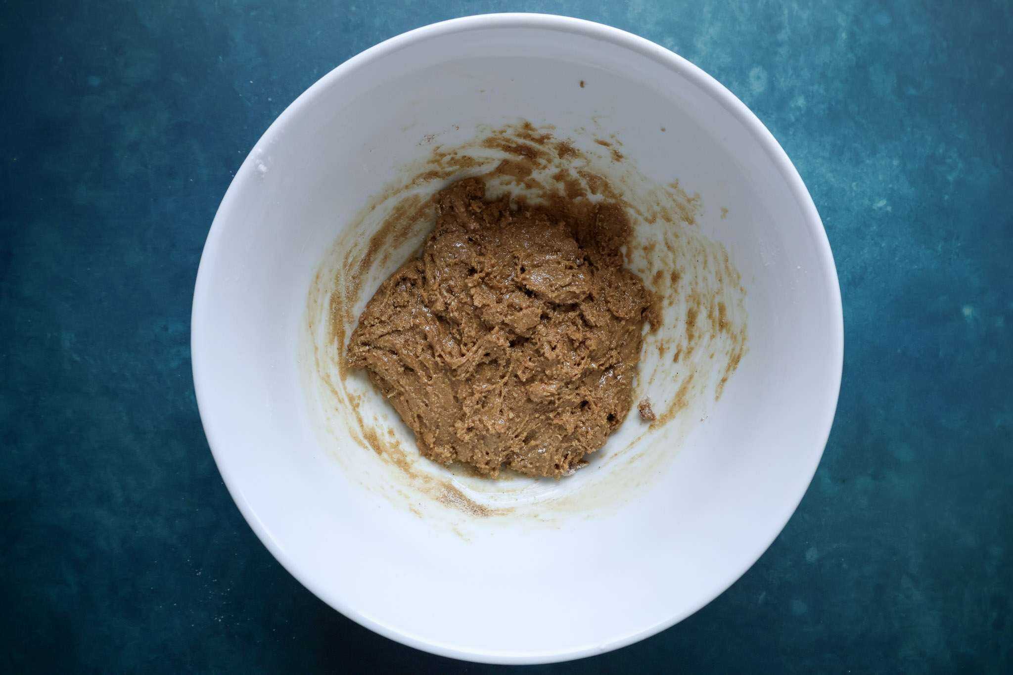 a white bowl containing the wet and dry blended ingredients, minus the egg whites, for cranberry orange tiramisu pie
