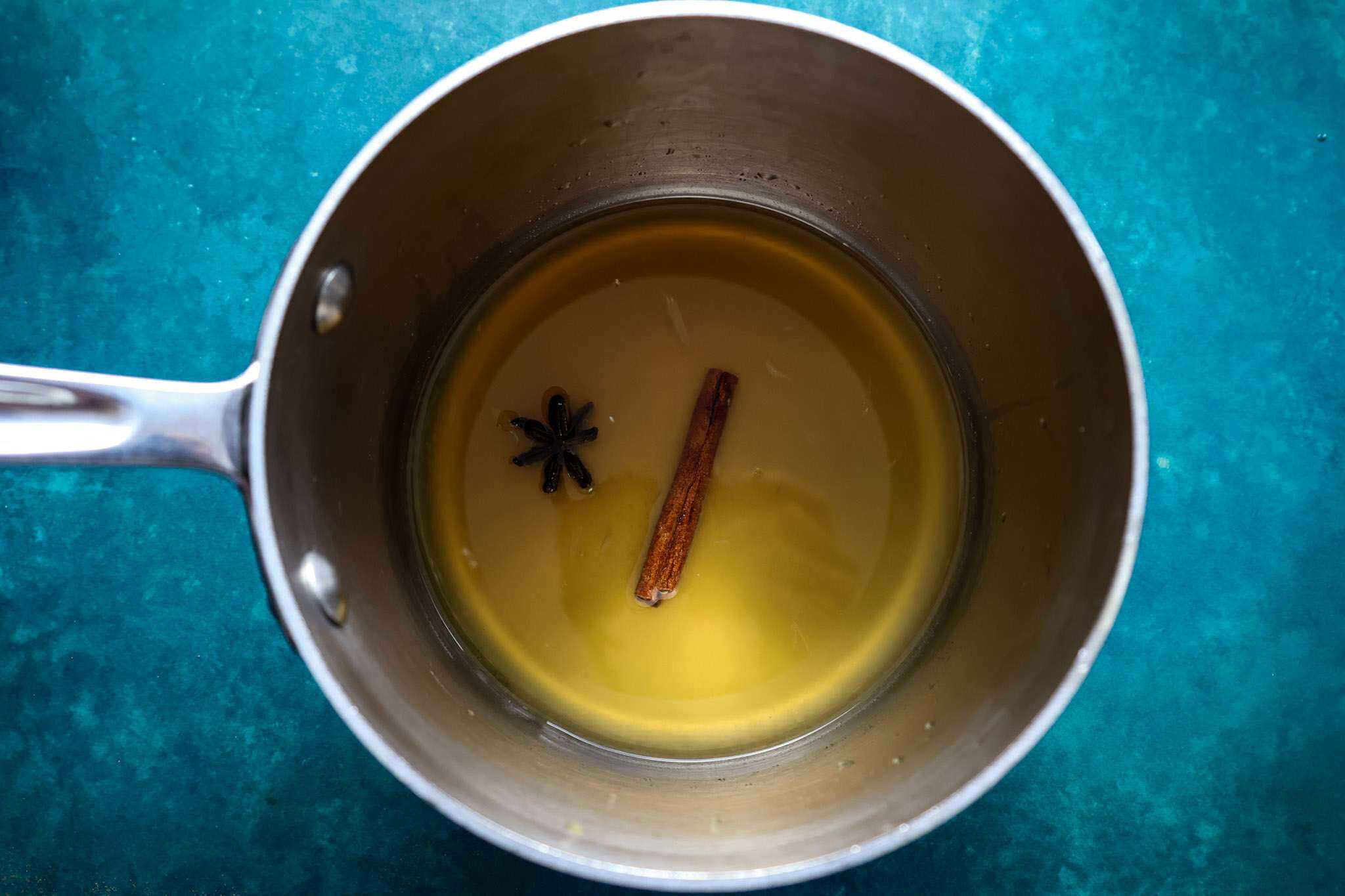 a small silver pot with all ingredients for the syrup for gluten-free cranberry orange tiramisu pie