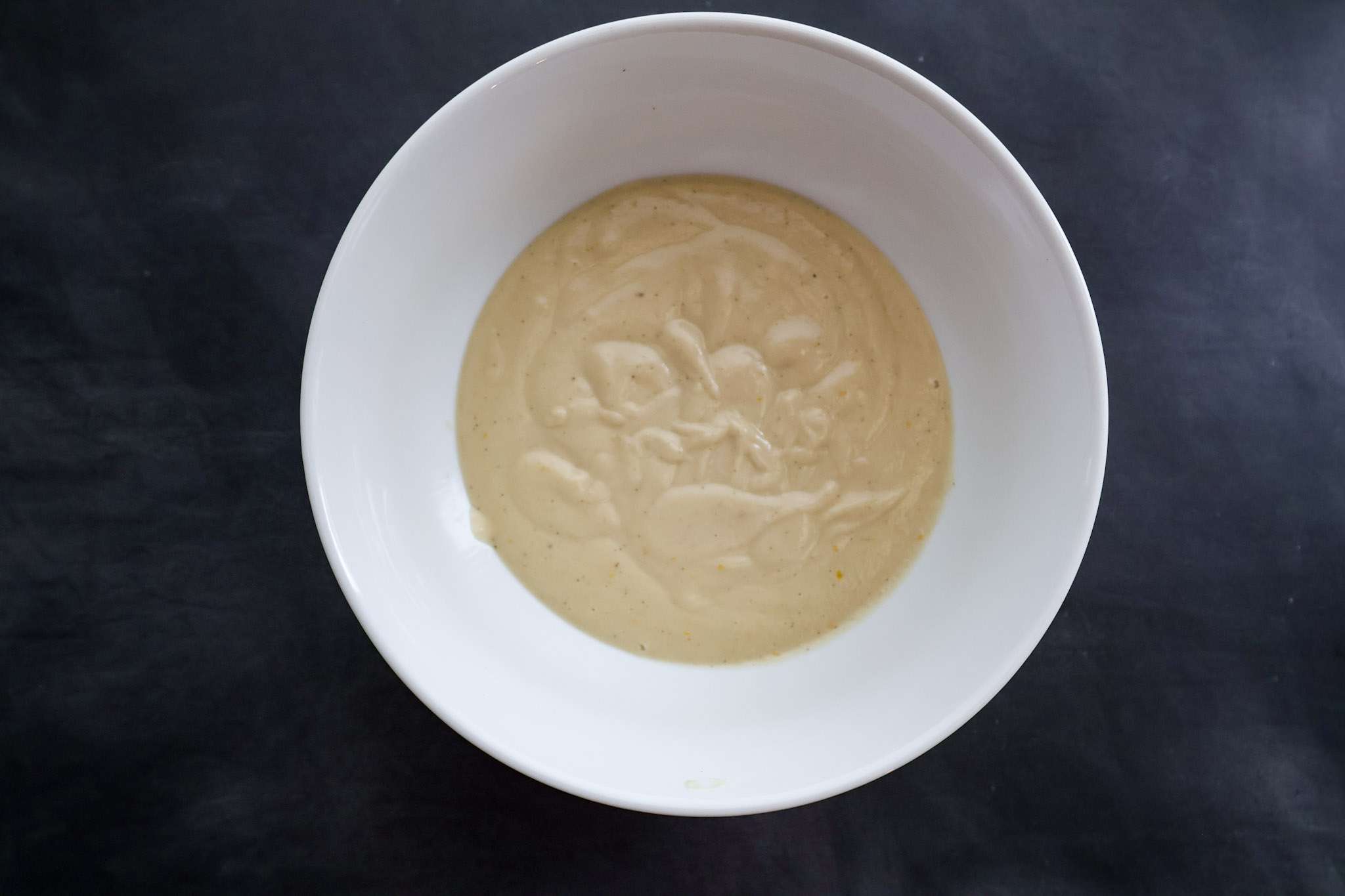 The blended cashew cream for dairy-free mascarpone style frosting in a while bowl