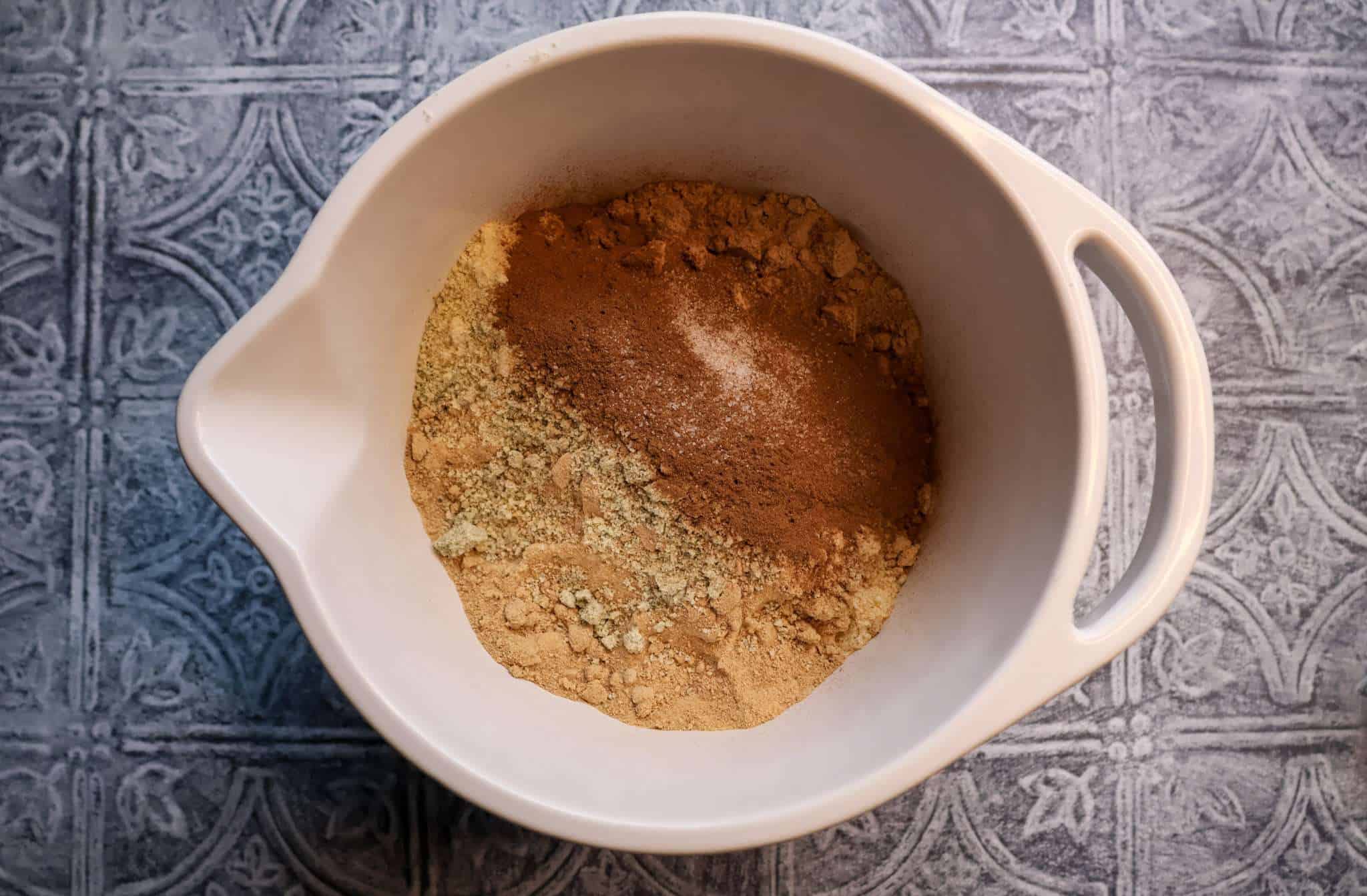 A white bowl with the dry ingredients for healthier zimtsterne dough