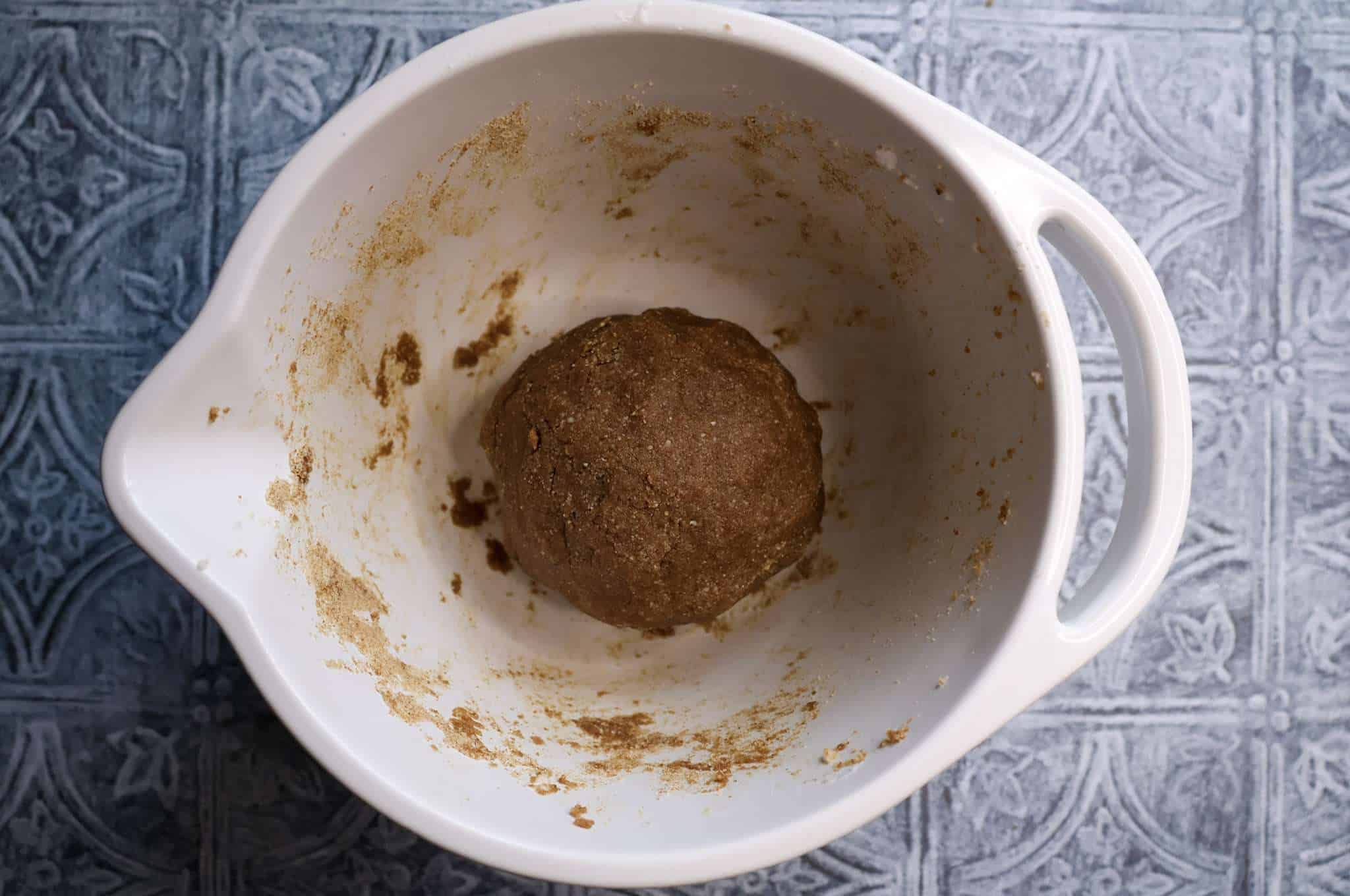 A white bowl with the dough for healthier zimtsterne