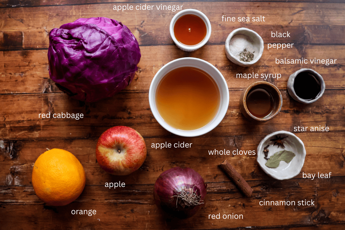 All ingredients for nourishing spiced red cabbage are displayed on a wooden surface and labeled
