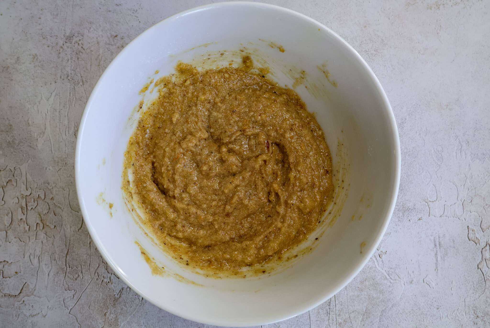 Batter for orange frangipane style cake in a white bowl