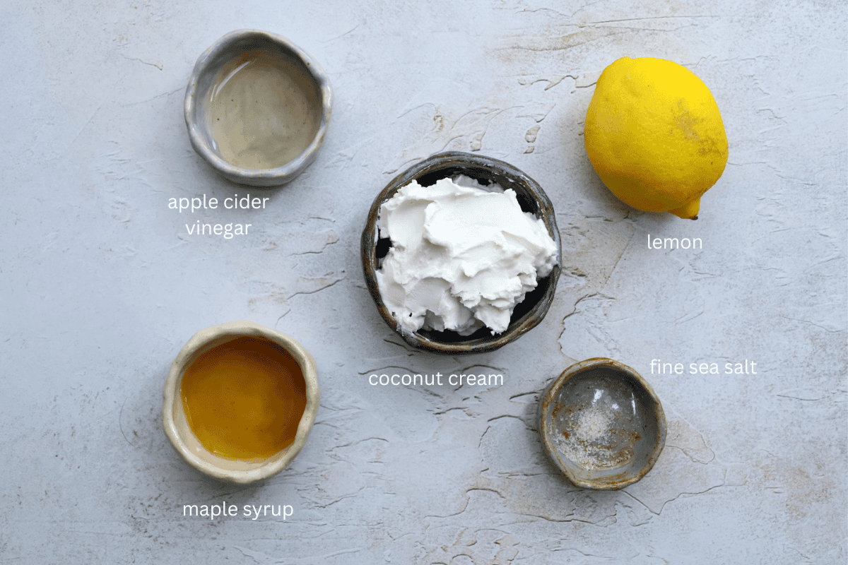 All ingredients for easy coconut creme fraiche are displayed on a concrete style surface and labeled