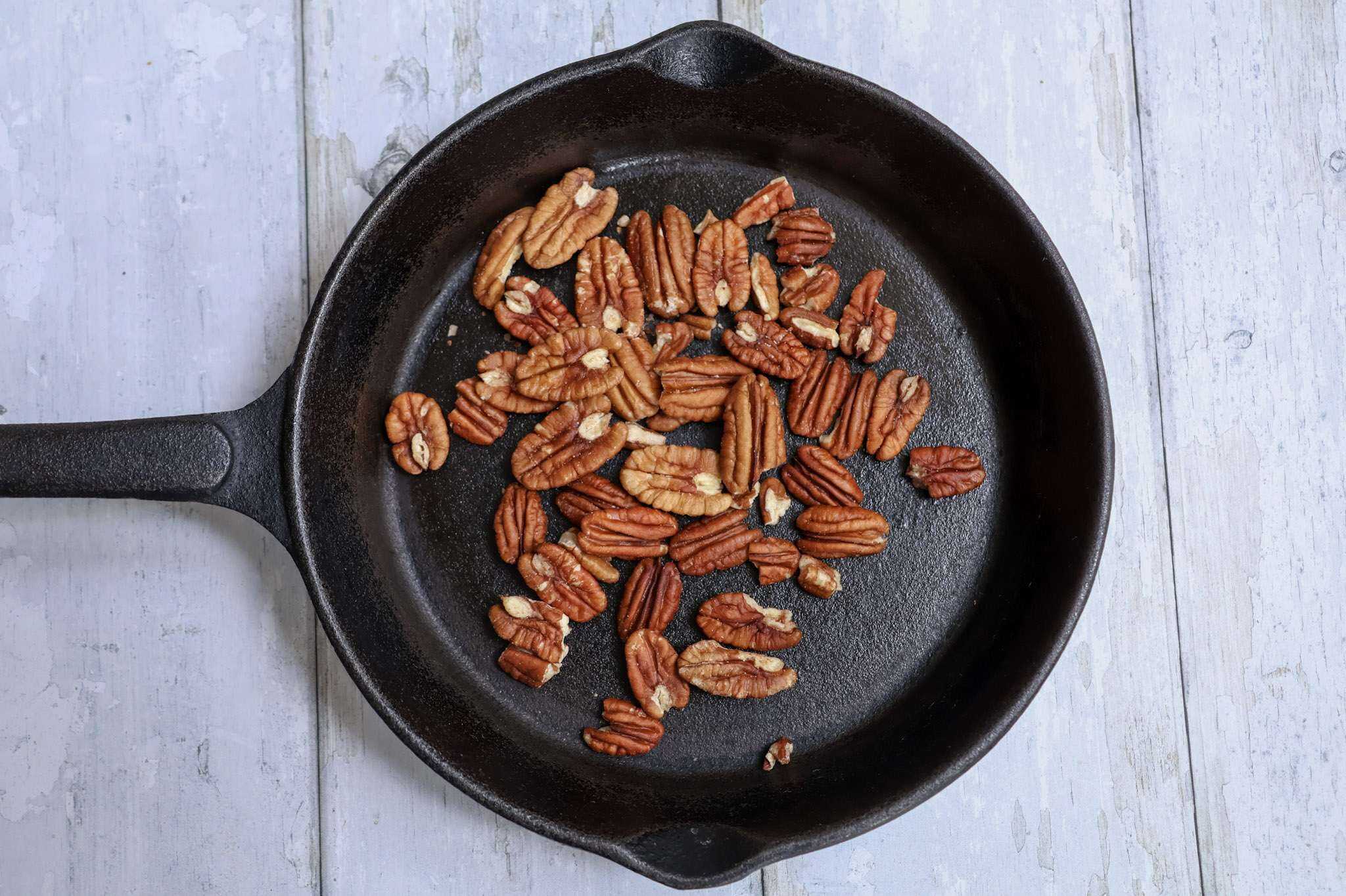 Pecans toasting in a cast iron pan