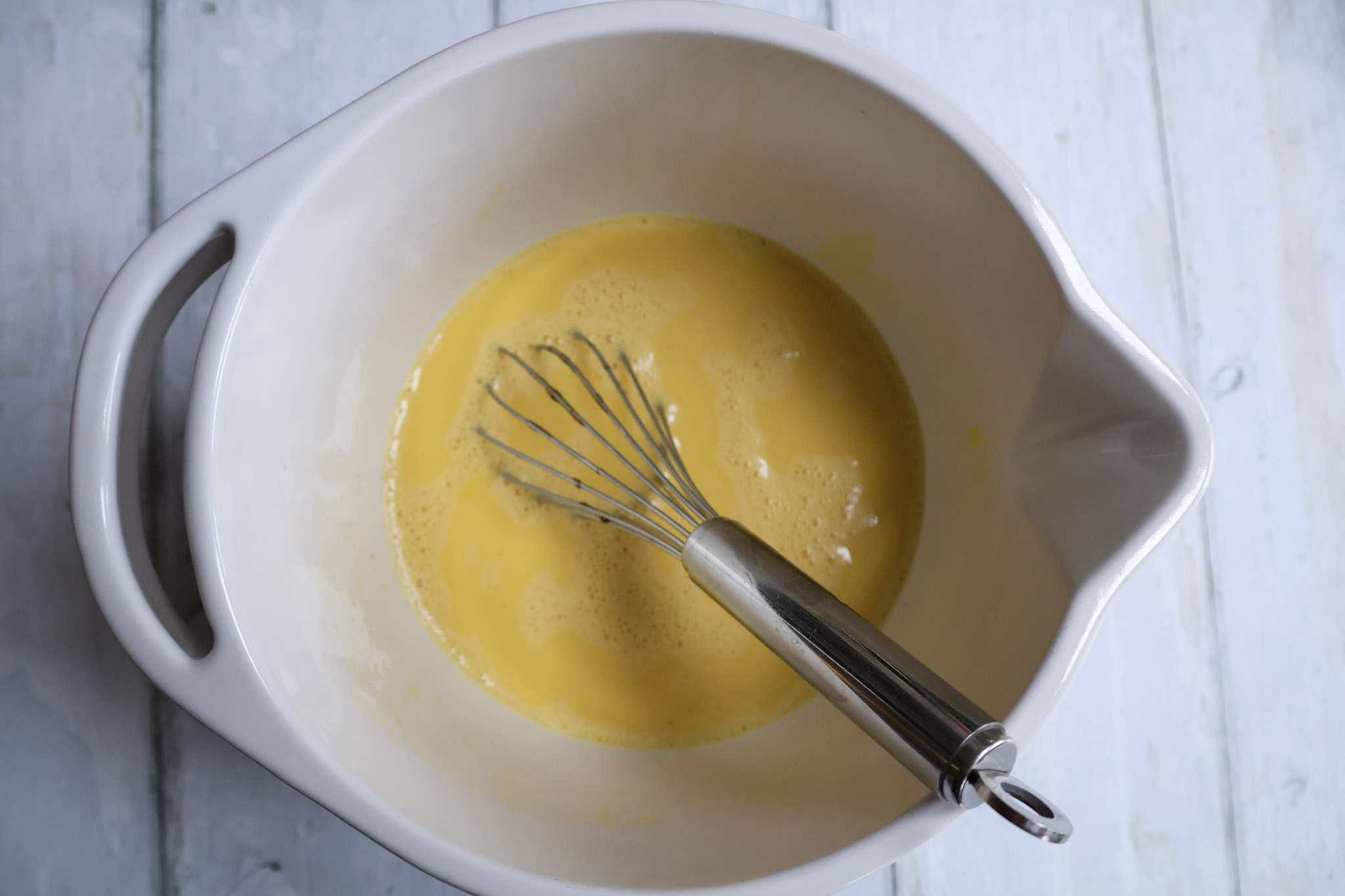 whisked eggs in a white bowl