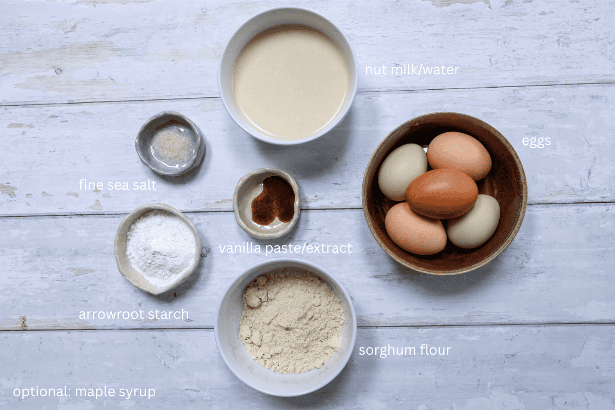 All ingredients for light and tender gluten-free crepes on a rustic white surface - labeled