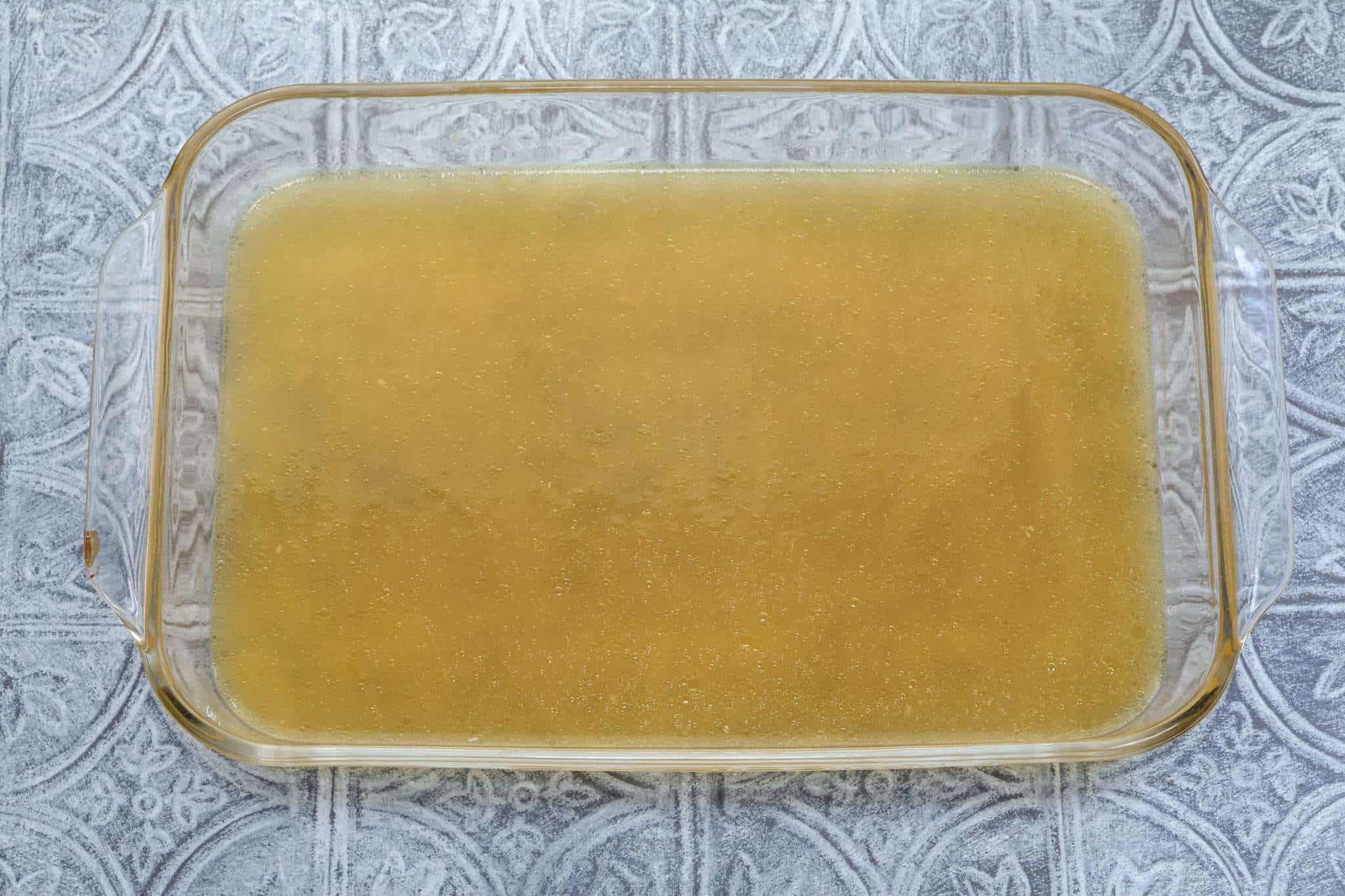 A clear casserole dish holding the still liquid citrus granita mixture