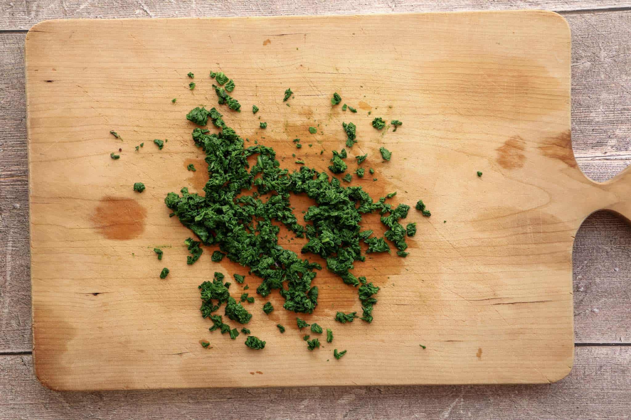 finely chopped blanchedbeet green on a wooden board