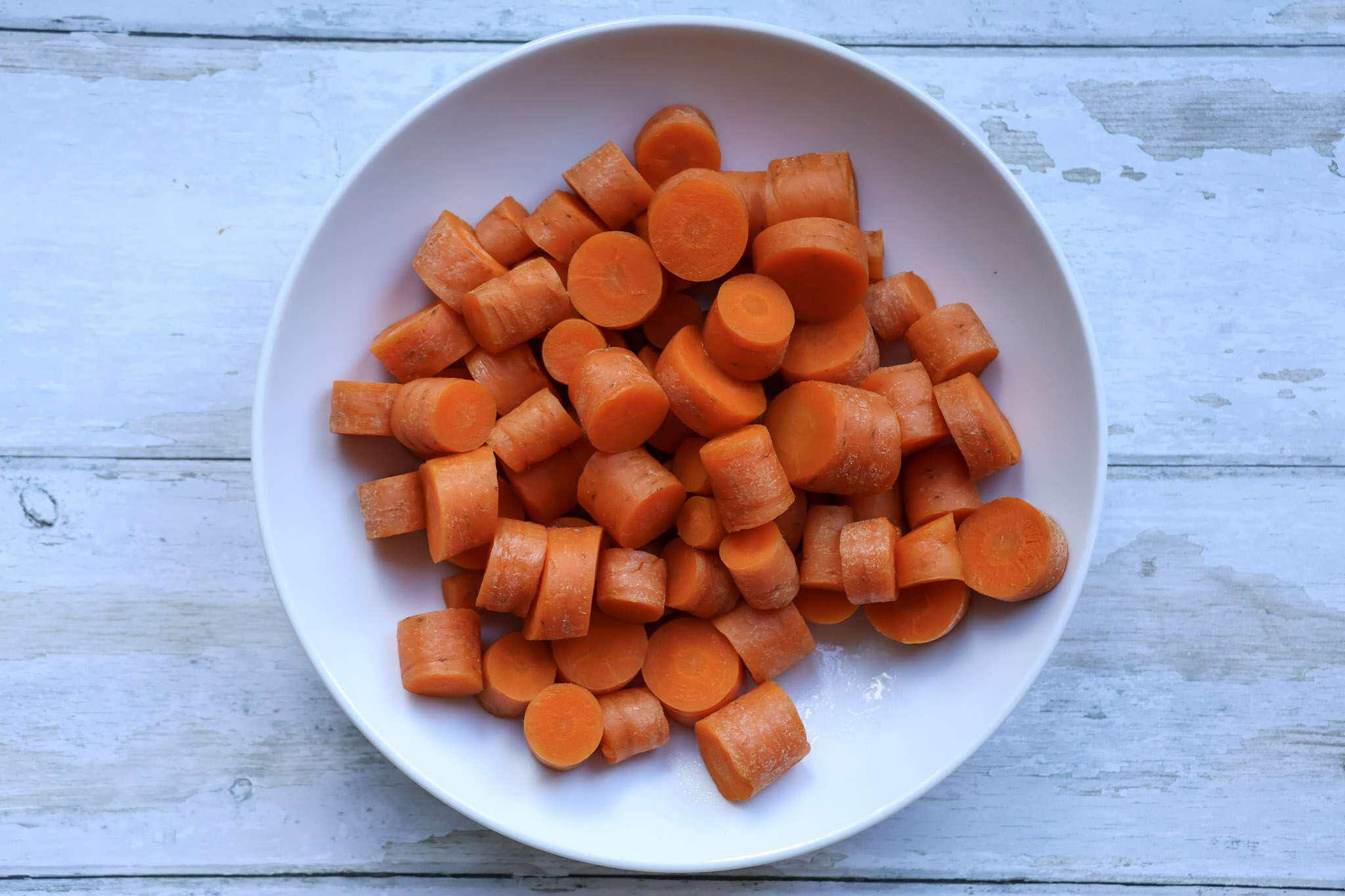 A white bowl with steamed carrot chunks