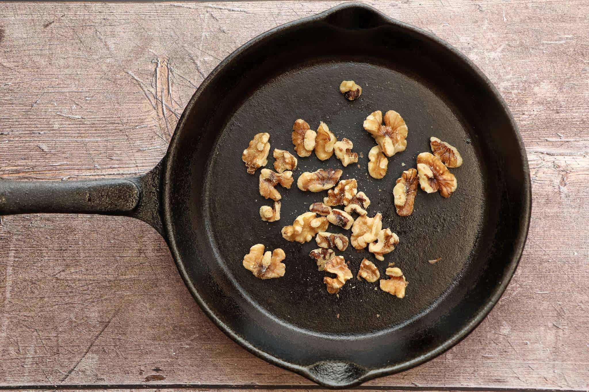 walnuts toasting in a cast iron skillet