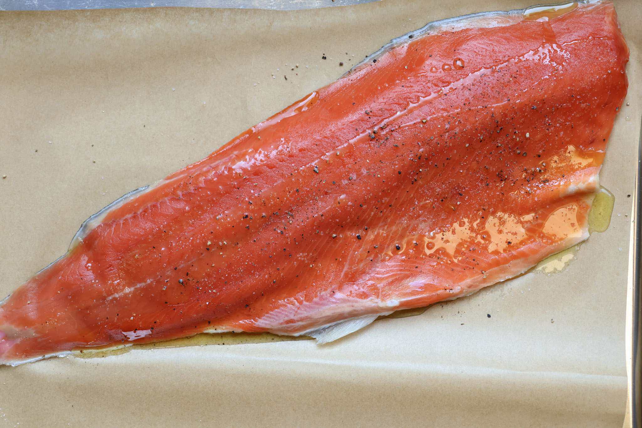 a side of seasoned salmon on a parchment lined baking sheet