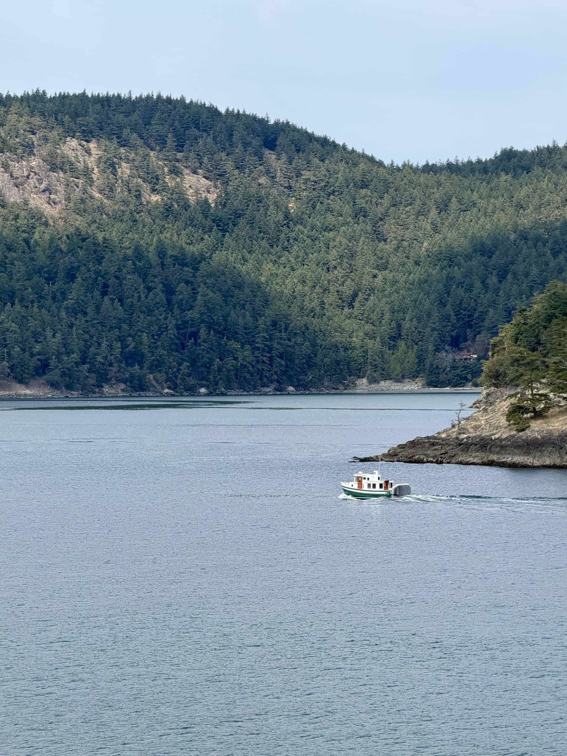 A view of the mountains and ocean around san juan island and a small boat in the water
