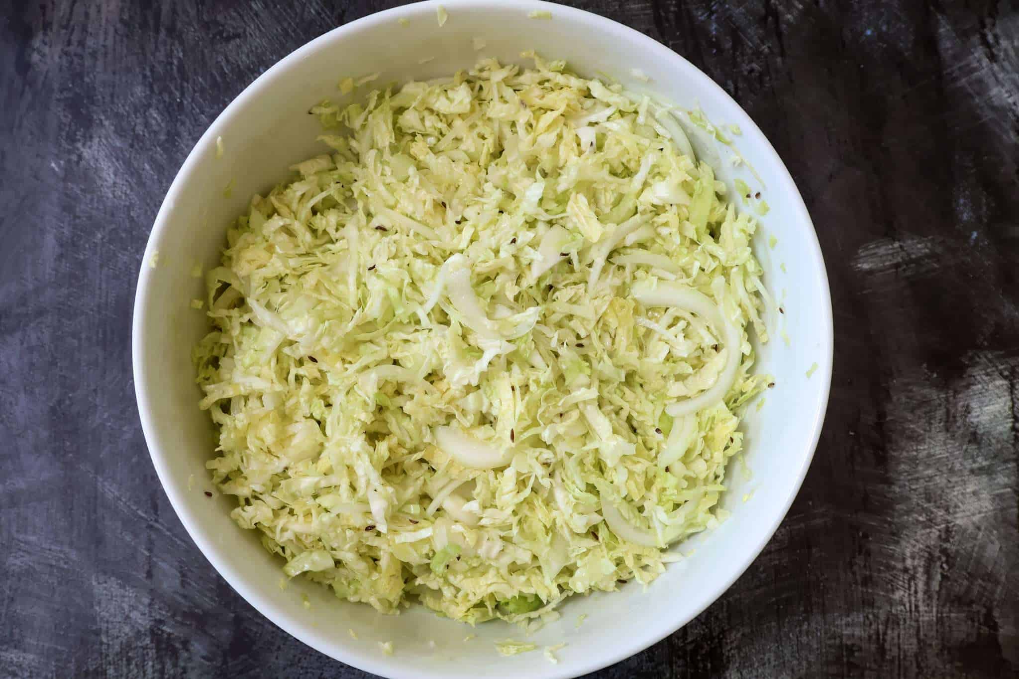 German Krautsalat that has just been tossed in a large white bowl