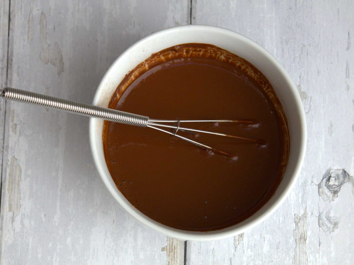 cacao paste in a small white bowl with a whisk