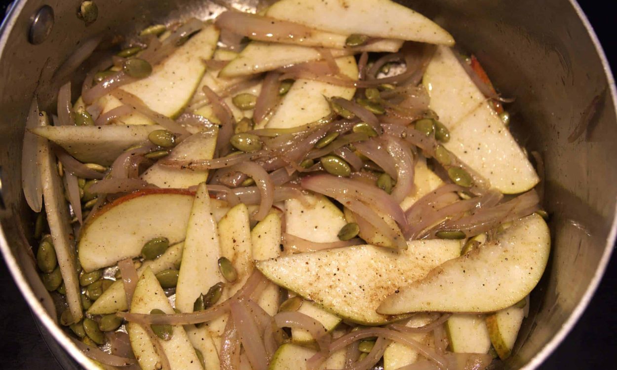 pears and shallots slices pears, shallots and pumpkin seeds sauteing in a pot